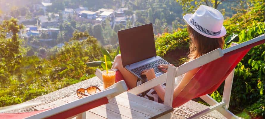 A person sitting on a deck with a computer and a cup of coffee

Description automatically generated with low confidence