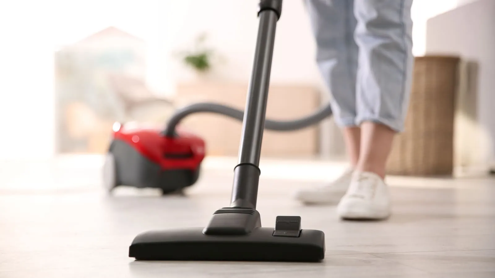 Woman cleaning with using a vacuum cleaner