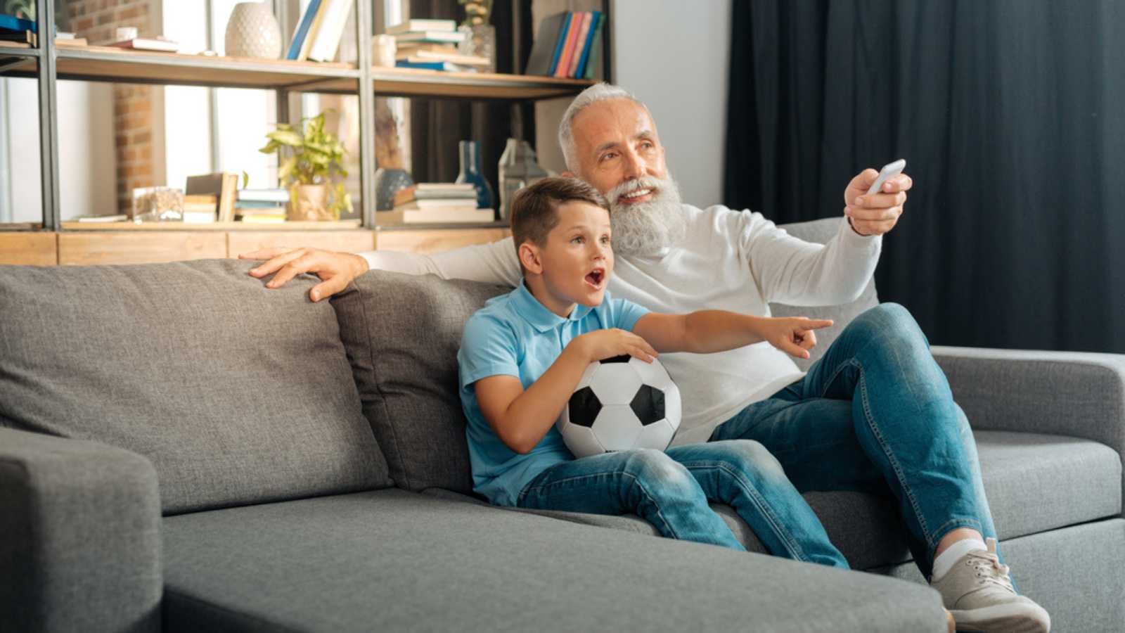 Boomer man watching news with grandson