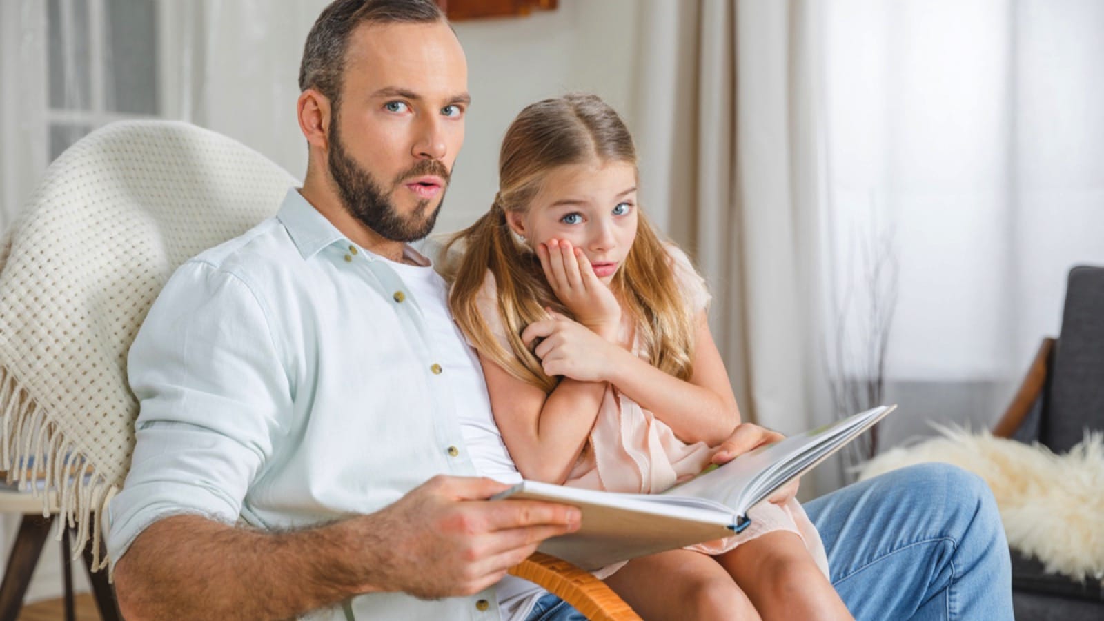 Father and daughter reading book scared